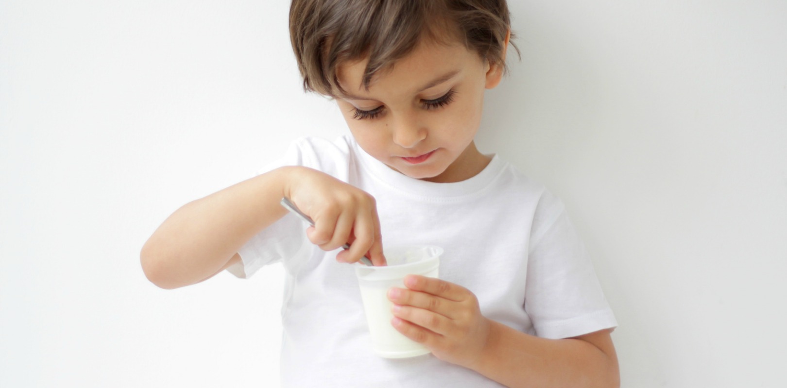 little boy eating yogurt